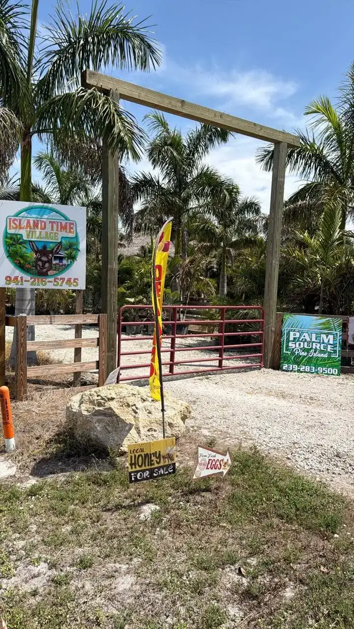 The farm gate with Island Time Village and Palm Source of Pine Island signs