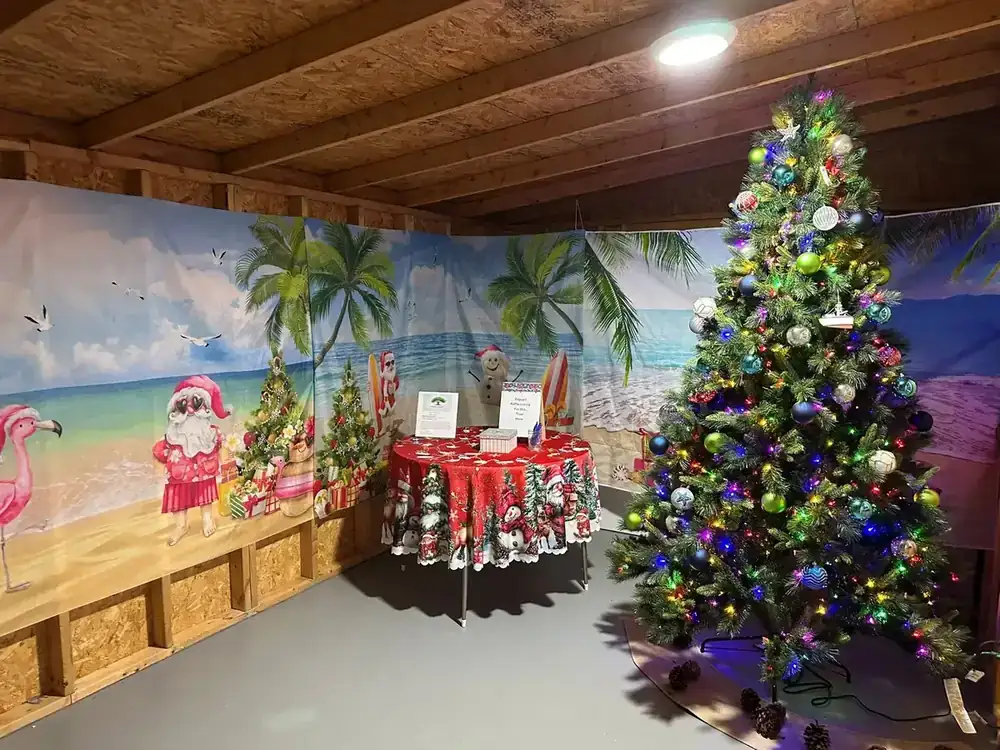 A decorated raffle Christmas tree in front of a beach backdrop